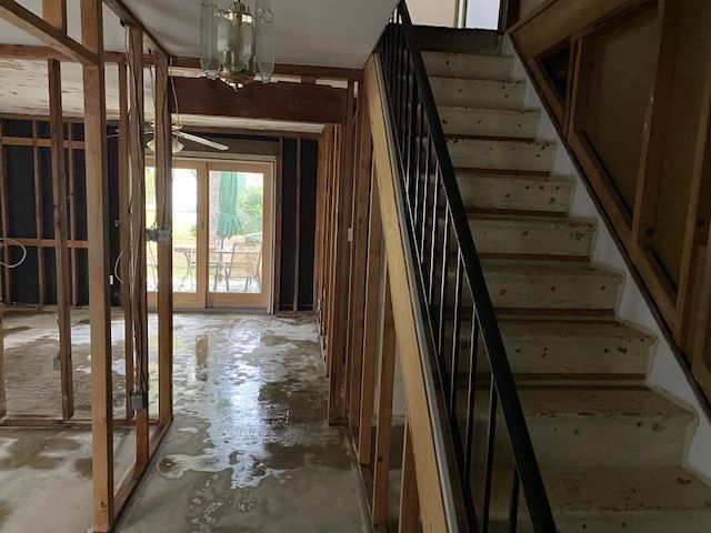 Staircase area cleared after asbestos abatement with patio door in background